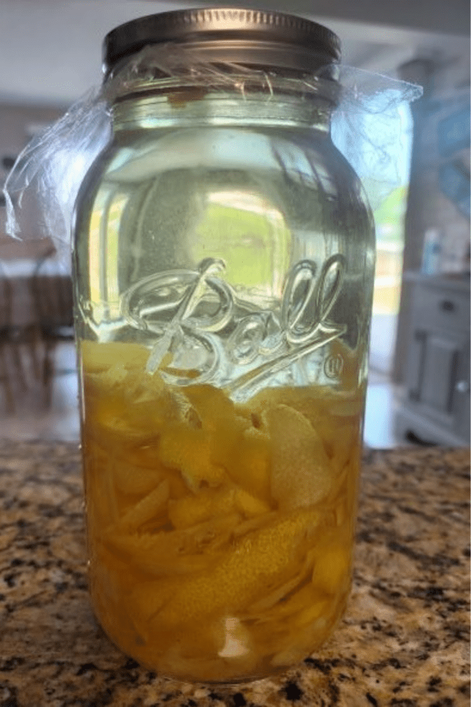 Homemade limoncello fermenting in a canning jar