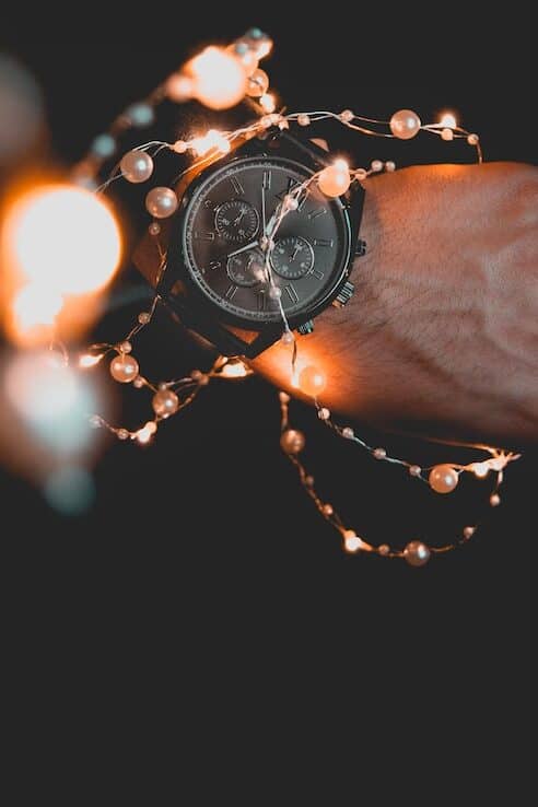 person wearing a watch and string lights