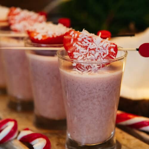 A row of Spiked strawberry Milkshake shots with strawberry garnish