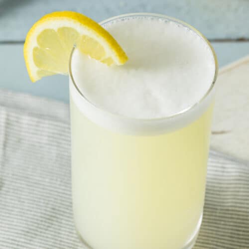 Gin Fizz cocktail with a foamy top and a lemon garnish