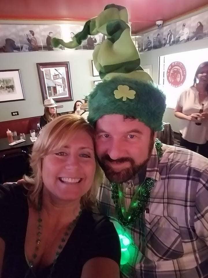 Two people wearing green one in a leprechaun hat