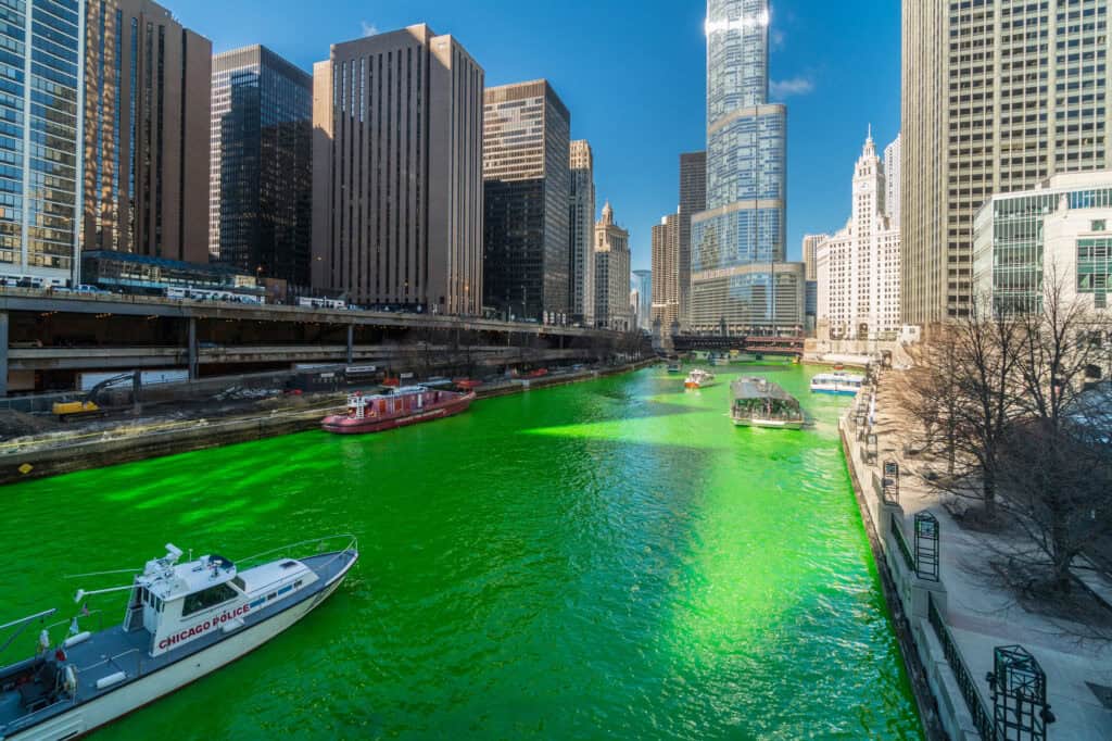 Green Chicago River with boats and skyline for St. Patrick's Day