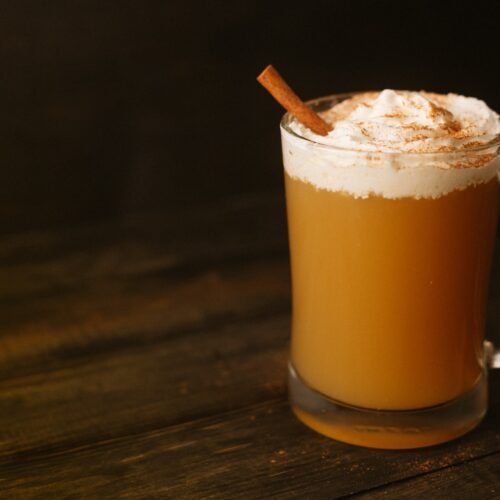 Warm cider with Licor 43, cream on top and cinnamon stick