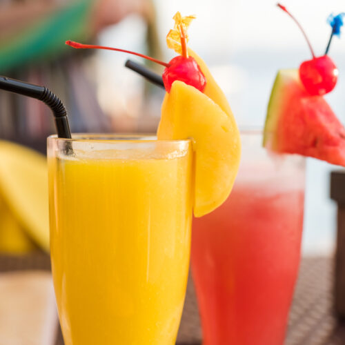 Mango Daiquiri with a Watermelon Daiquiri in glasses with straws.