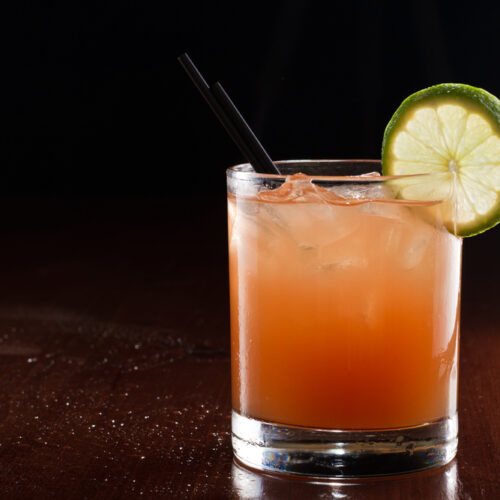 Springtime screwdriver cocktail in a rocks glass with ice and a lime garnish