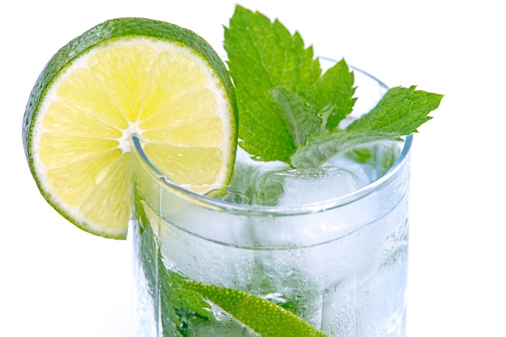 Fresh lime and mint in a glass of club soda and vodka