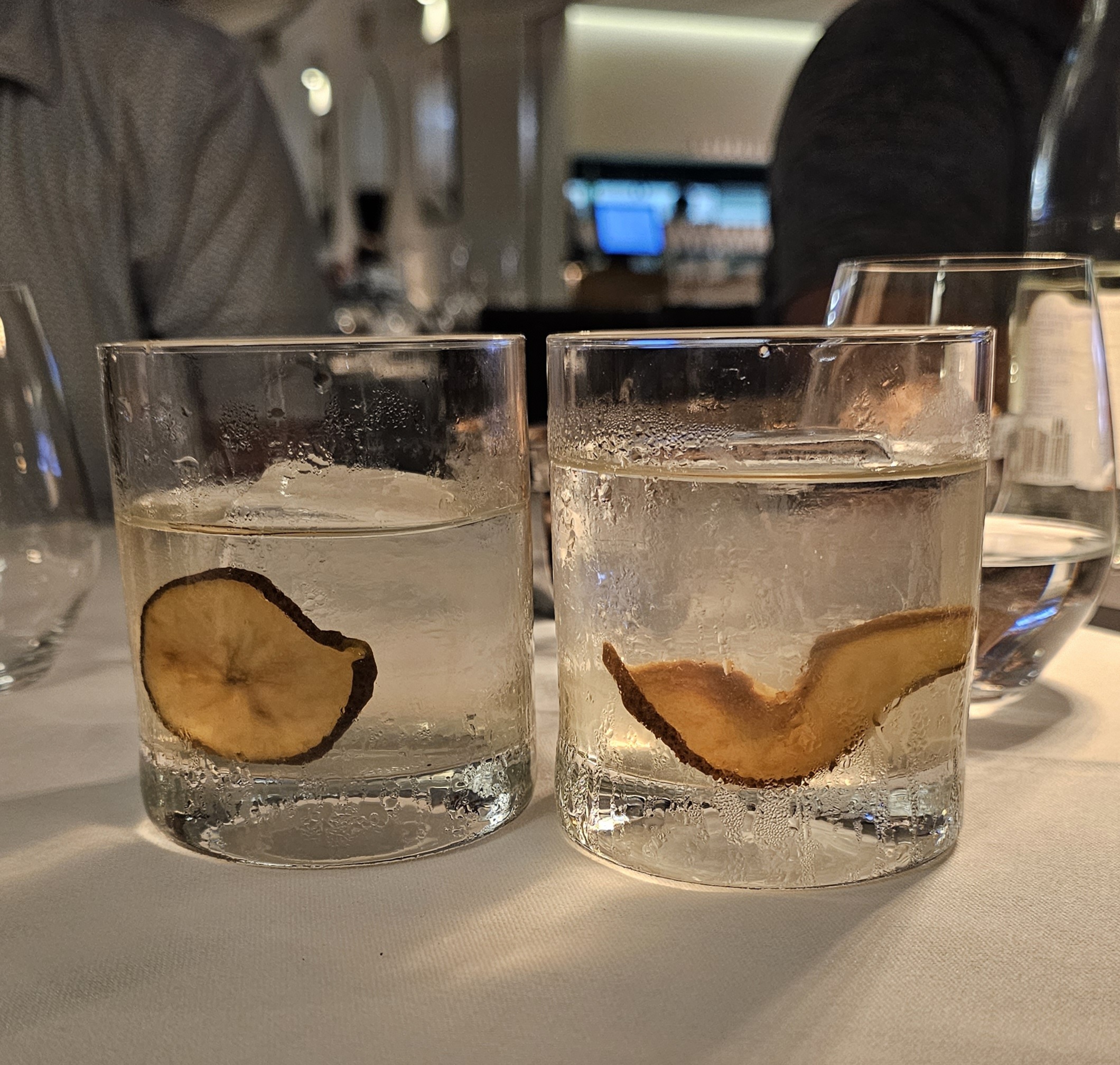Clarified Cocktails with pear slices and large cube of ice