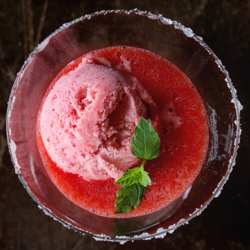 Raspberry Holiday Punch with a scoop of raspberry sherbet and mint leaves in a glass