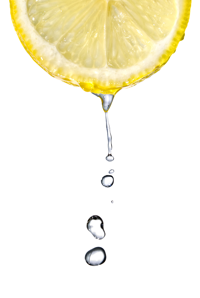Lemon juice dripping from the bottom of a lemon