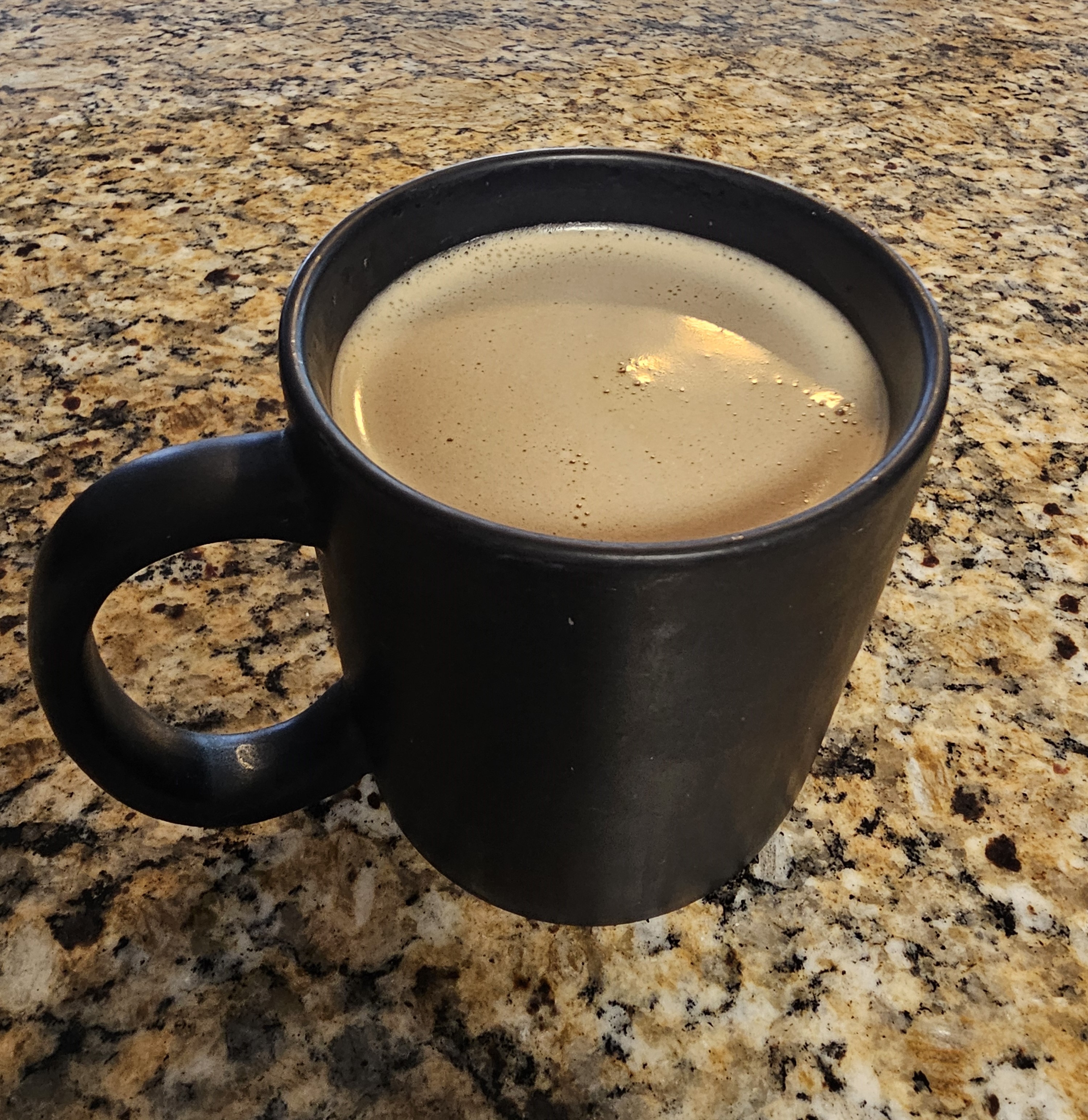 Black mug filled with coffee and homemade Baileys Irish Cream