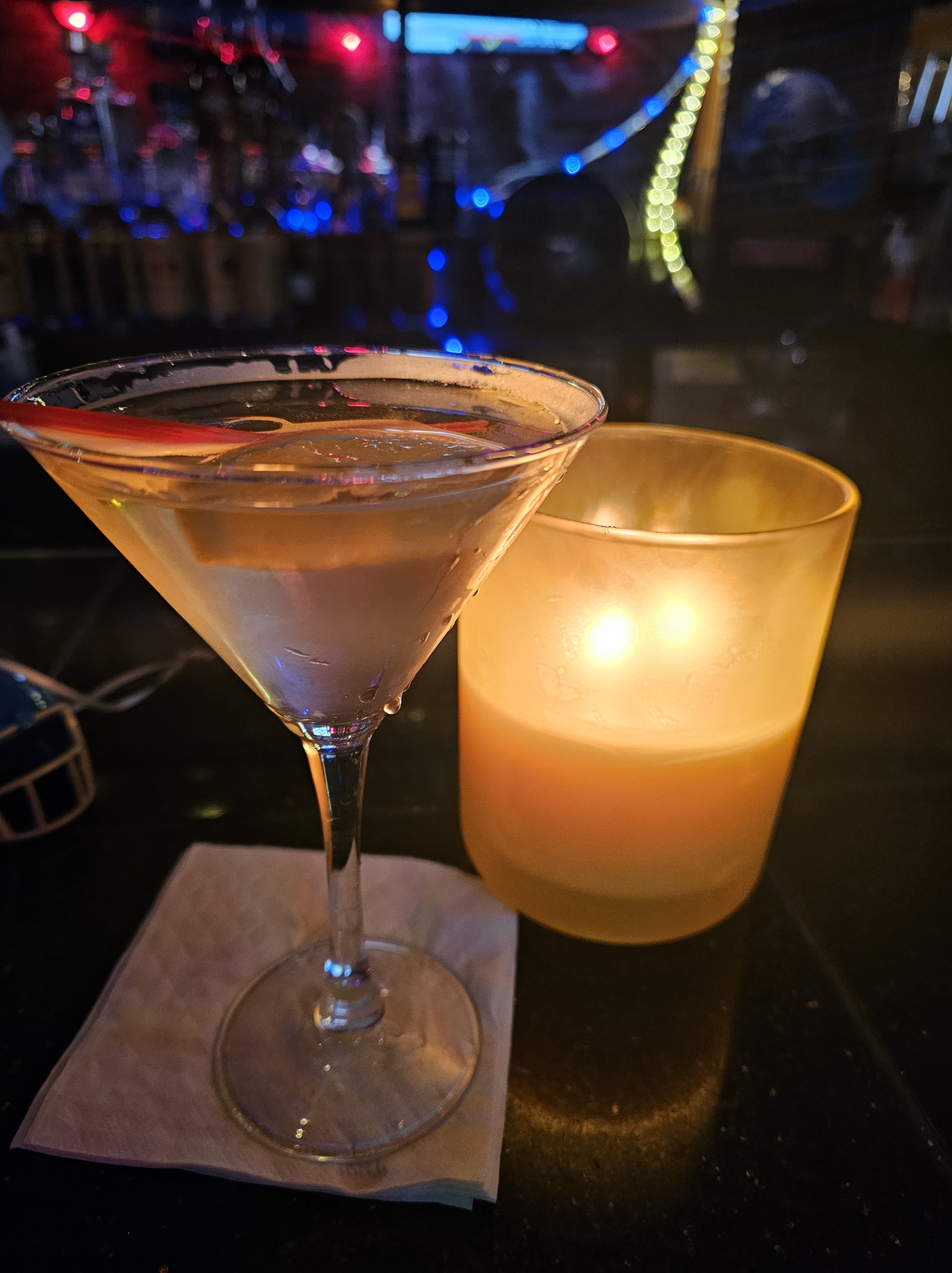 A Pear Martini with a candle next to it giving off light