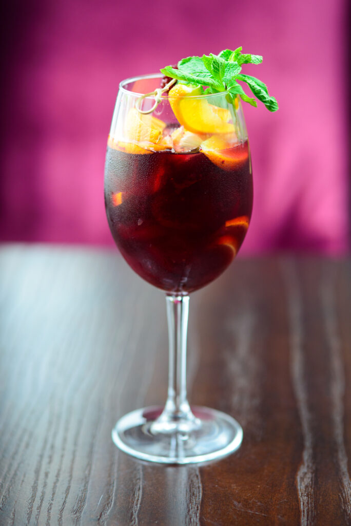 Charming St. Patrick's Day Cocktails include a Red Irish Sangria with Ice, a Lemon Slice and topped off with a mint garnish.