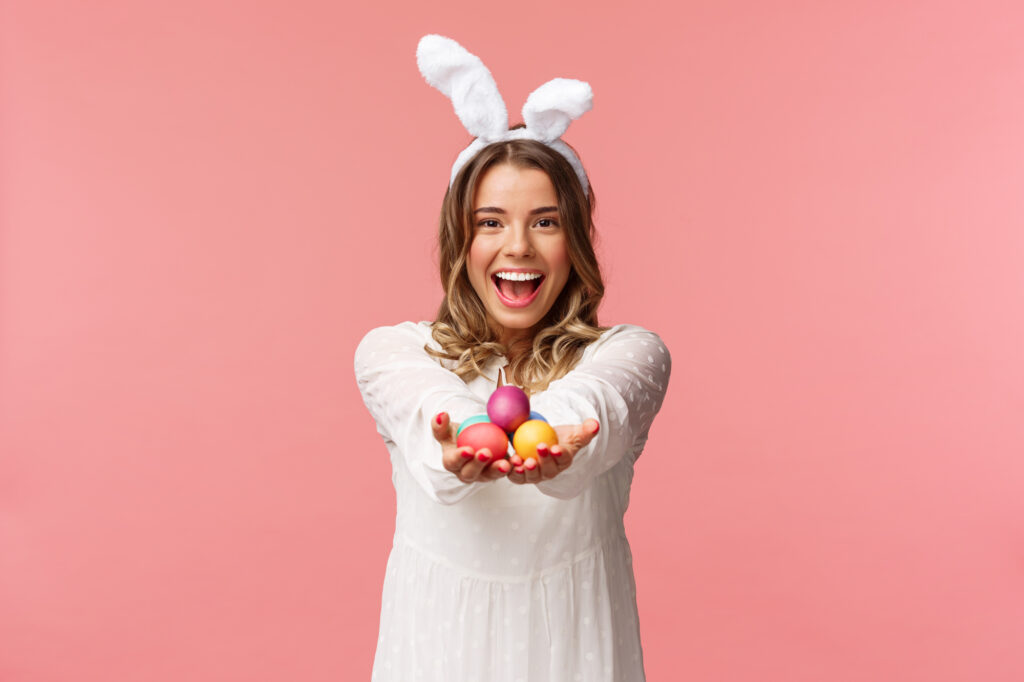 Adult Egg Hunt with a Woman wearing bunny ears and holding Easter Eggs