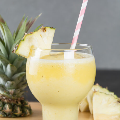 Pineapple Coconut Mojito with a slice of pineapple on the side