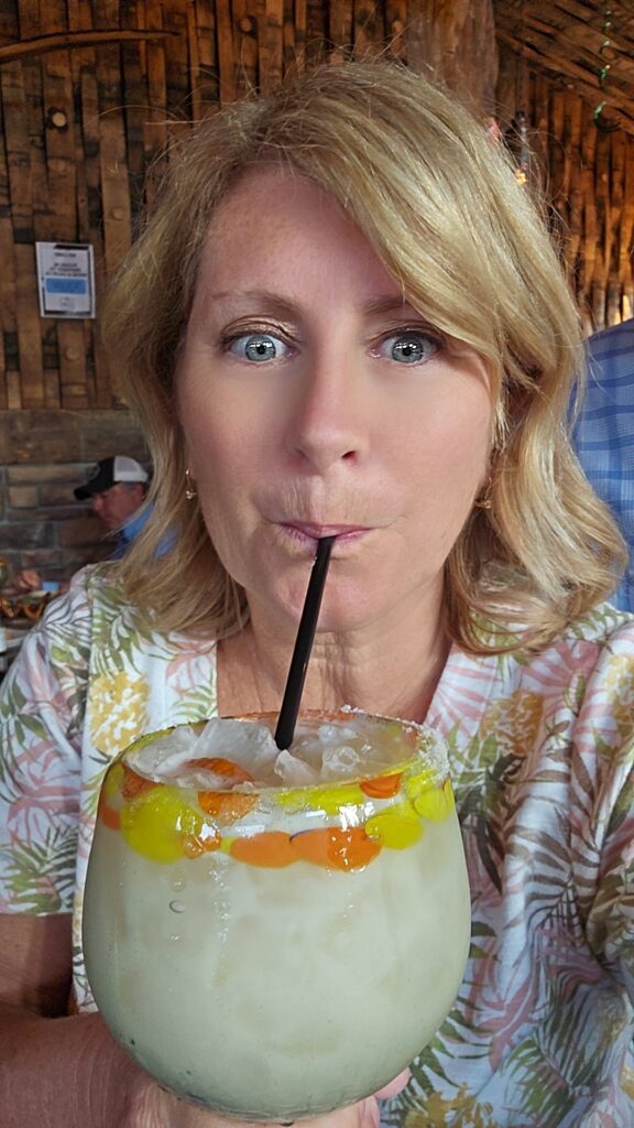 Woman enjoying a Coconut Margarita in a big margarita glass.