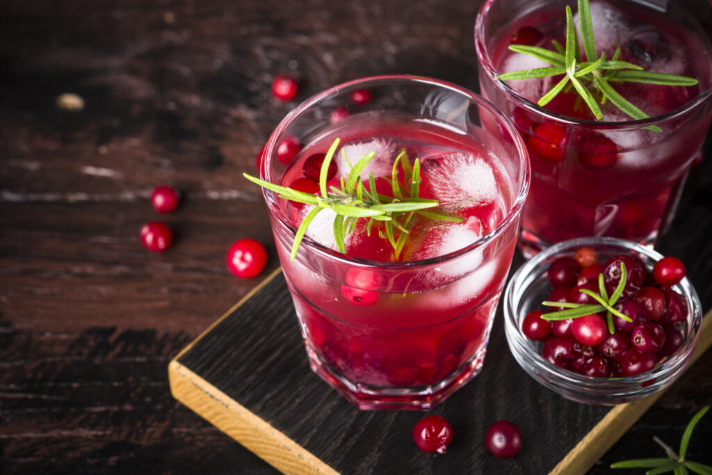 Cranberry Gin Fizz on a board with spilled cranberries