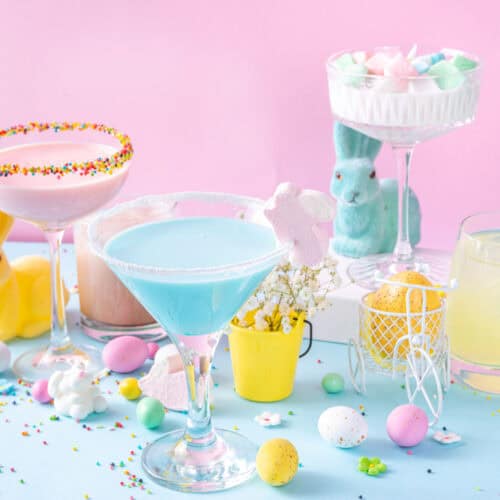 Three Easter cocktails with candy eggs and a blue Easter Bunny