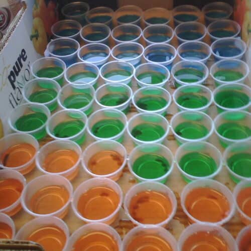 A tray of orange, green and blue jello shots