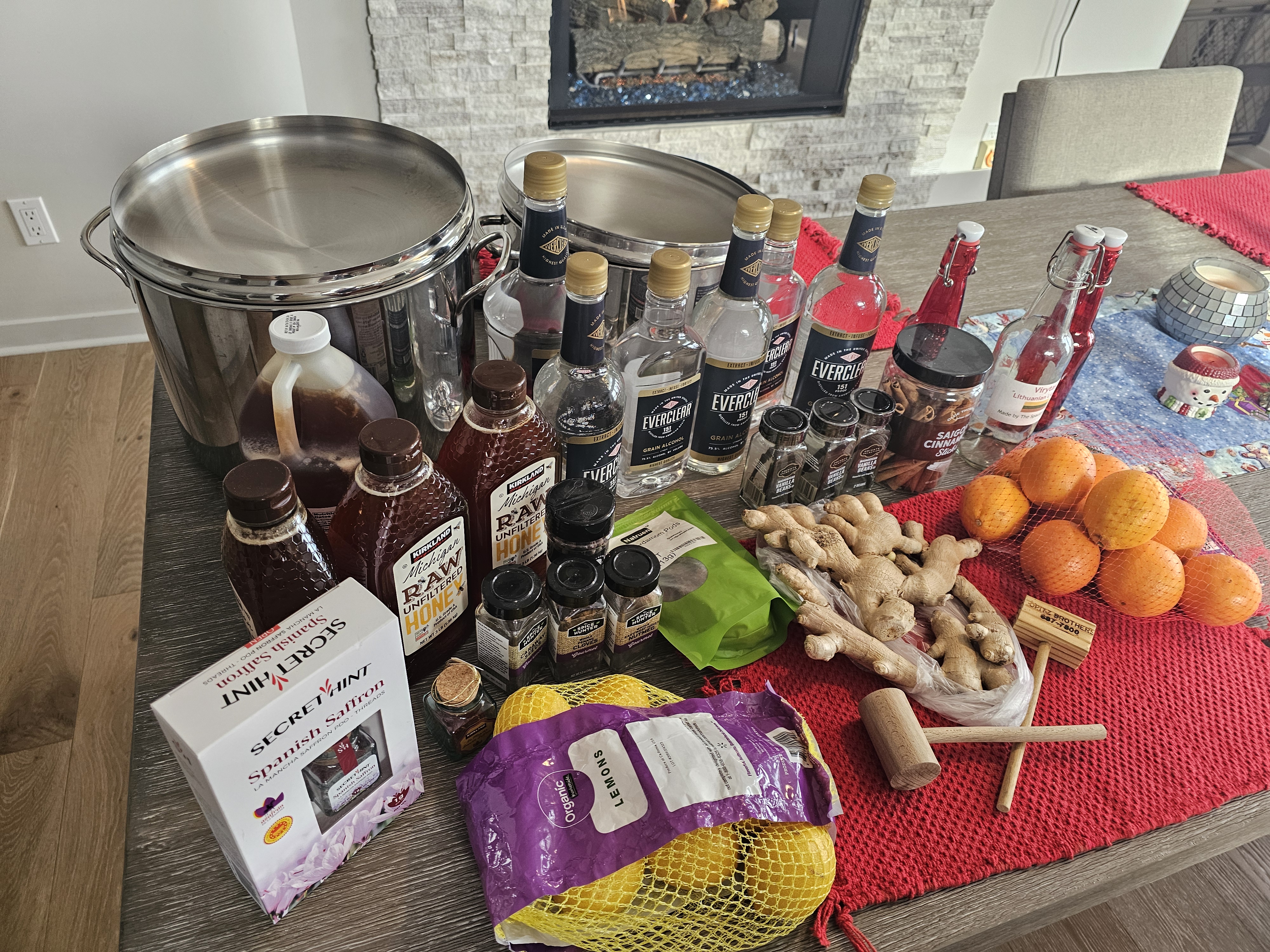 A table full of ingredients  including alcohol, fruit and spices.