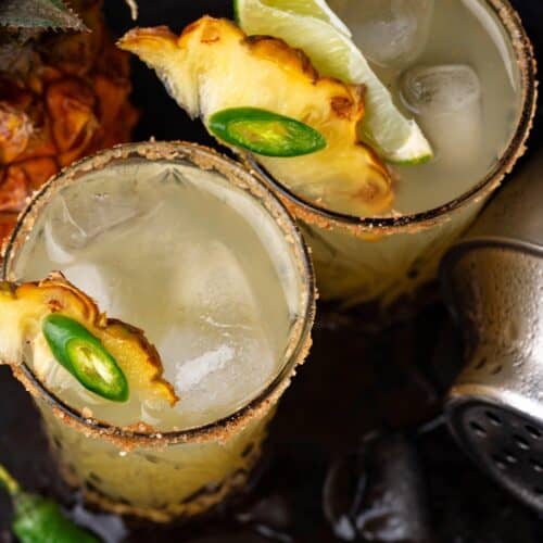2 Swicy Cocktails including Pineapple Jalapeno Smash in glasses on a tray with ice