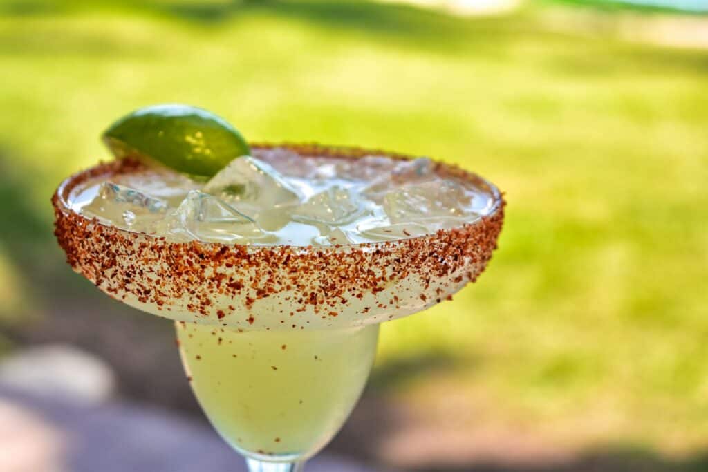 a close up of a Margarita with a Tajin rim