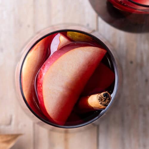 Red Cider Sangria with apple slices and a cinnamon stick