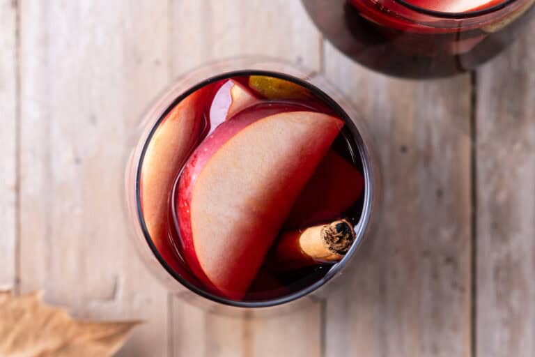 Red Cider Sangria with apple slices and a cinnamon stick