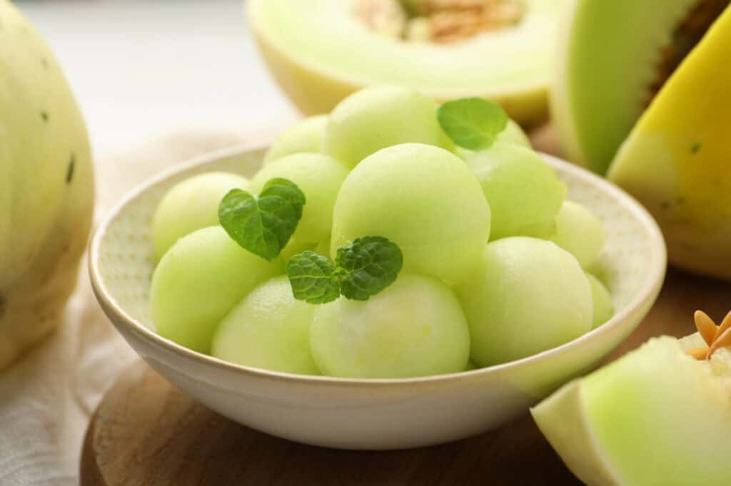 Honey Deuce Melon Balls in a bowl with sprigs of mint
