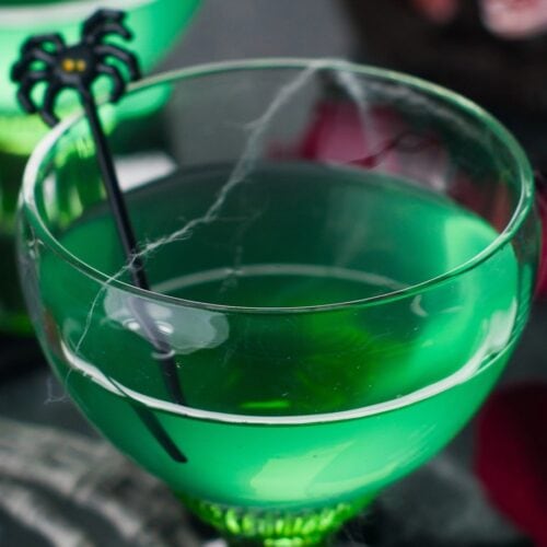 Witches Brew Cocktail with a spiderweb and spider drink stir