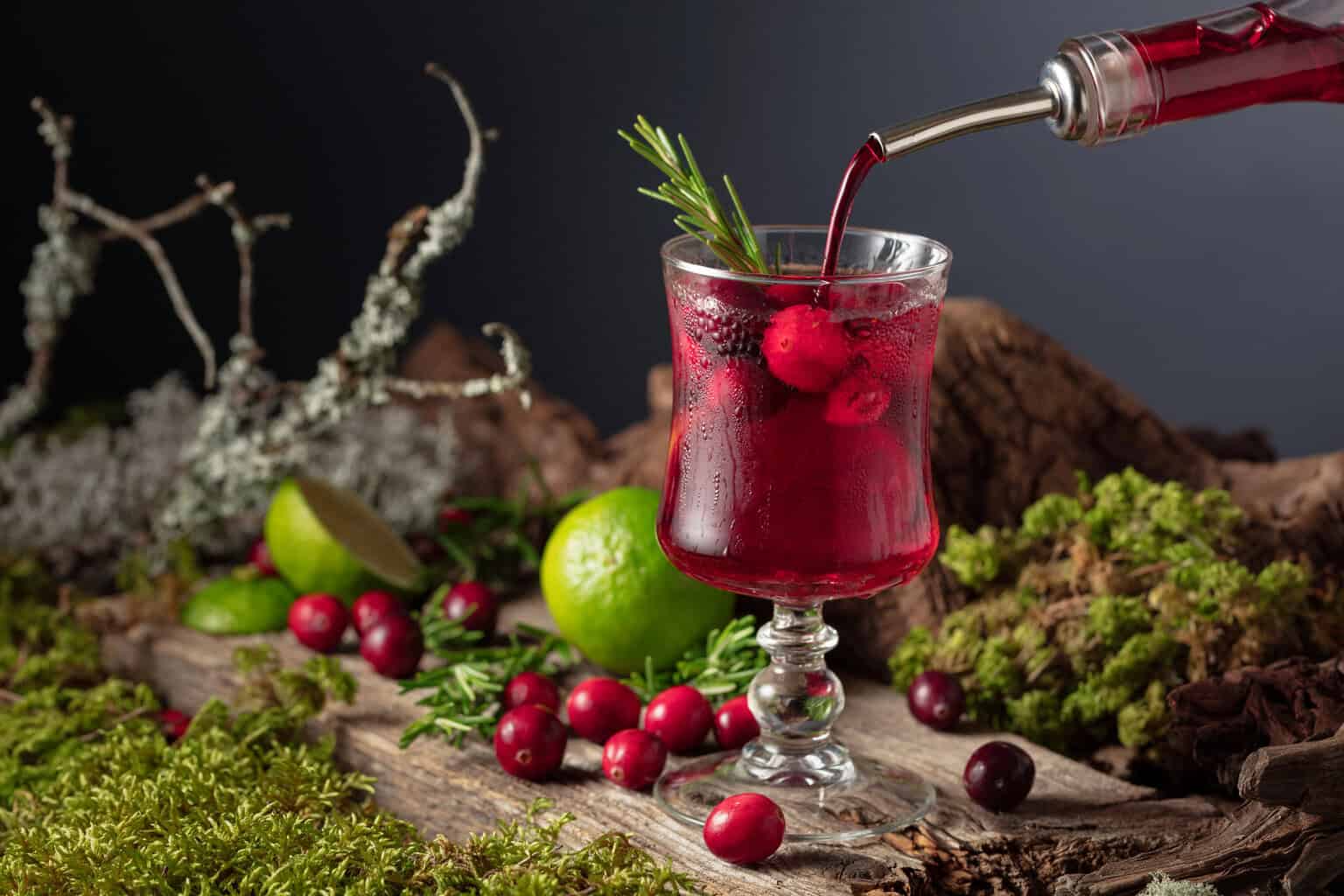 Cranberry Margarita in a glass with lime and cranberries on a wooden table