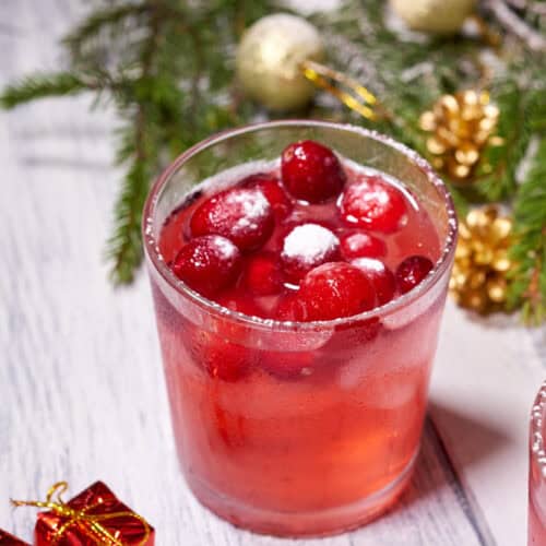 Merry Maker Cranberry Martini with Christmas ornaments on a wooden table