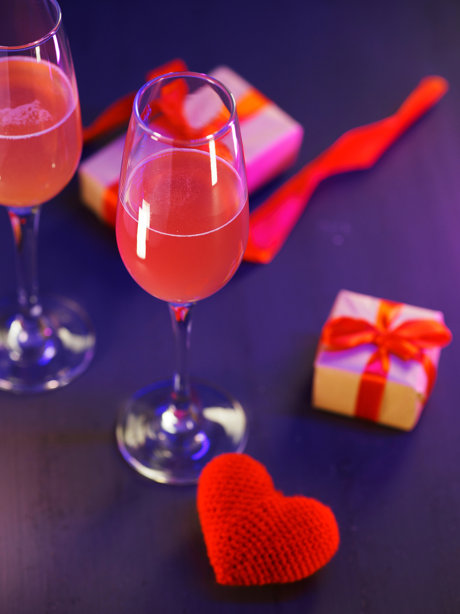 Pink Whitney cocktails with gift boxes and red heard on table
