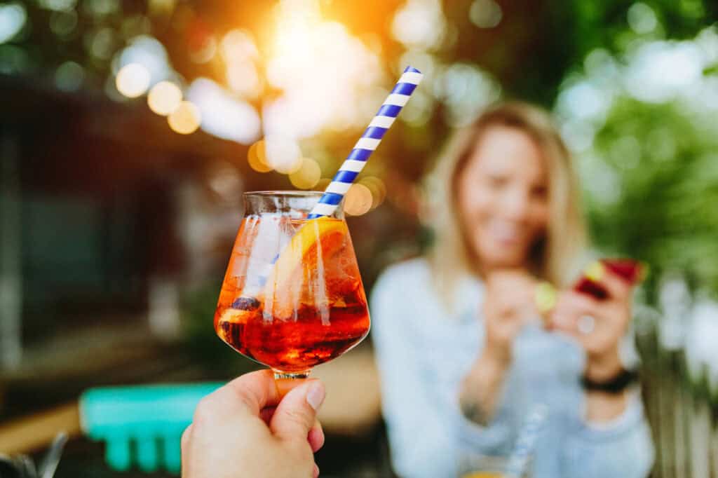 Aperol Spritz cocktail with a blue stra