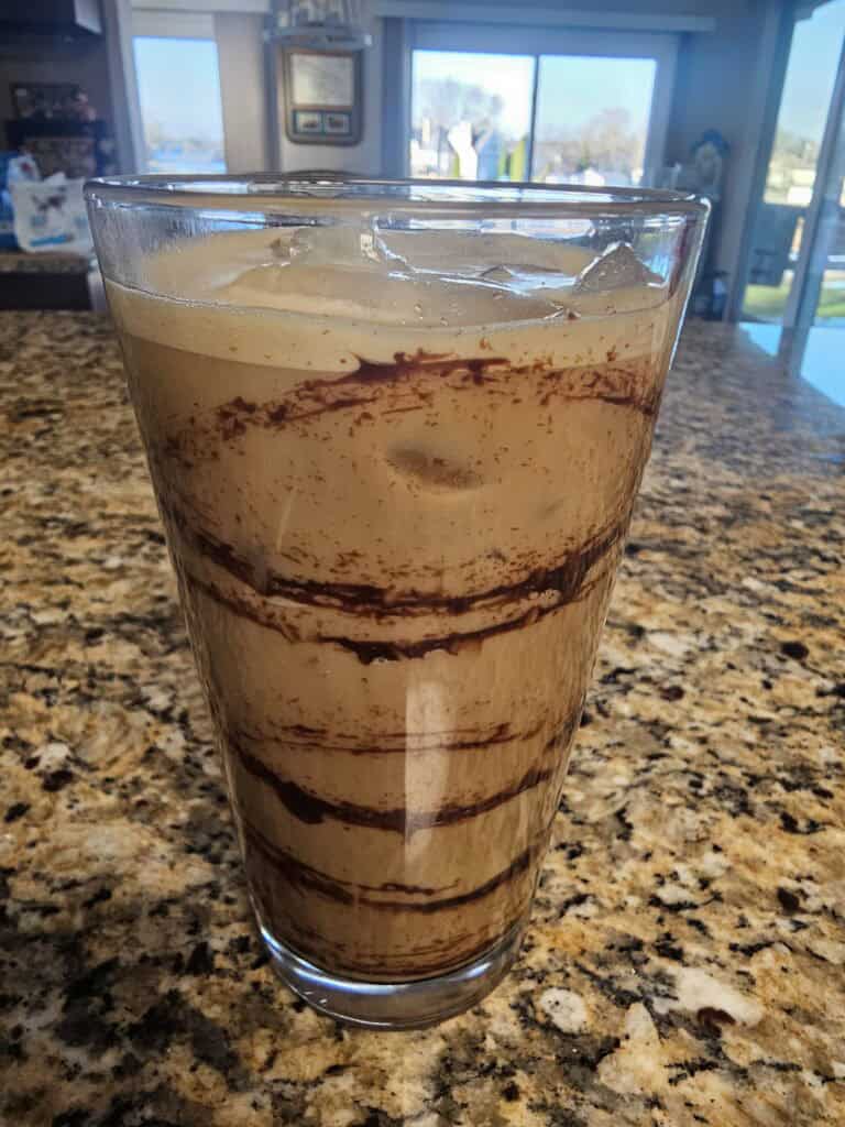 Iced Mocha Coffee with chocolate swirls in a pint glass