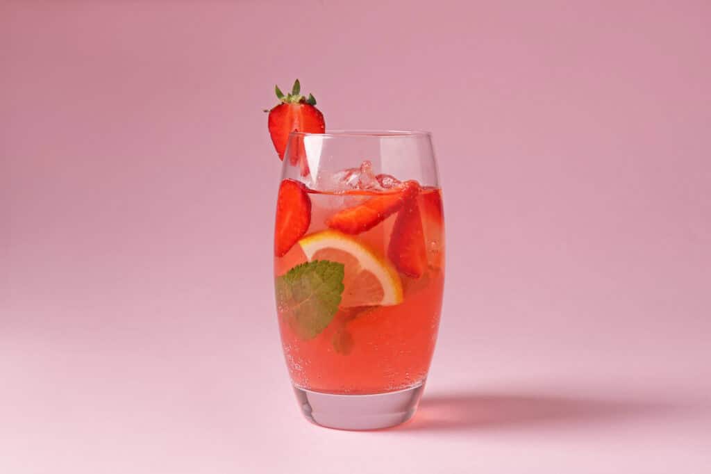 Garden Party Spritz in a champagne flute with a strawberry garnish